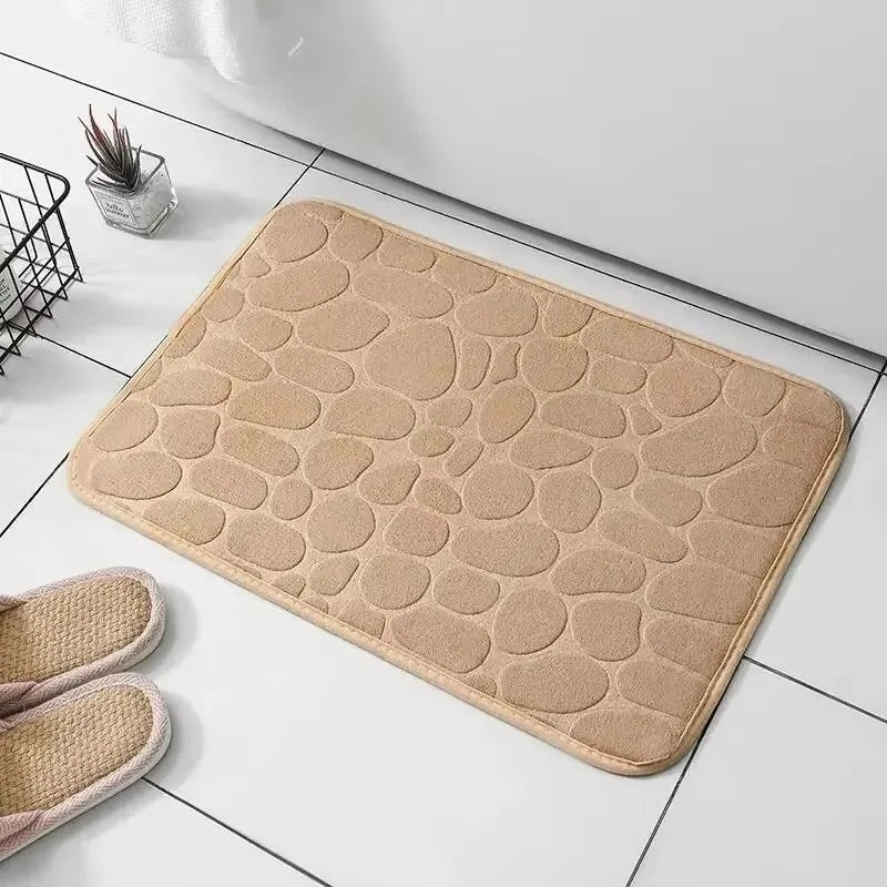 Alfombrilla de baño Variedad Online con diseño de guijarros en color beige, suave y absorbente.