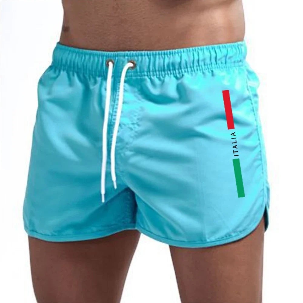 Bañadores cortos para hombre de Variedad Online en color azul claro con cordón blanco y detalle de la bandera italiana en el lateral.