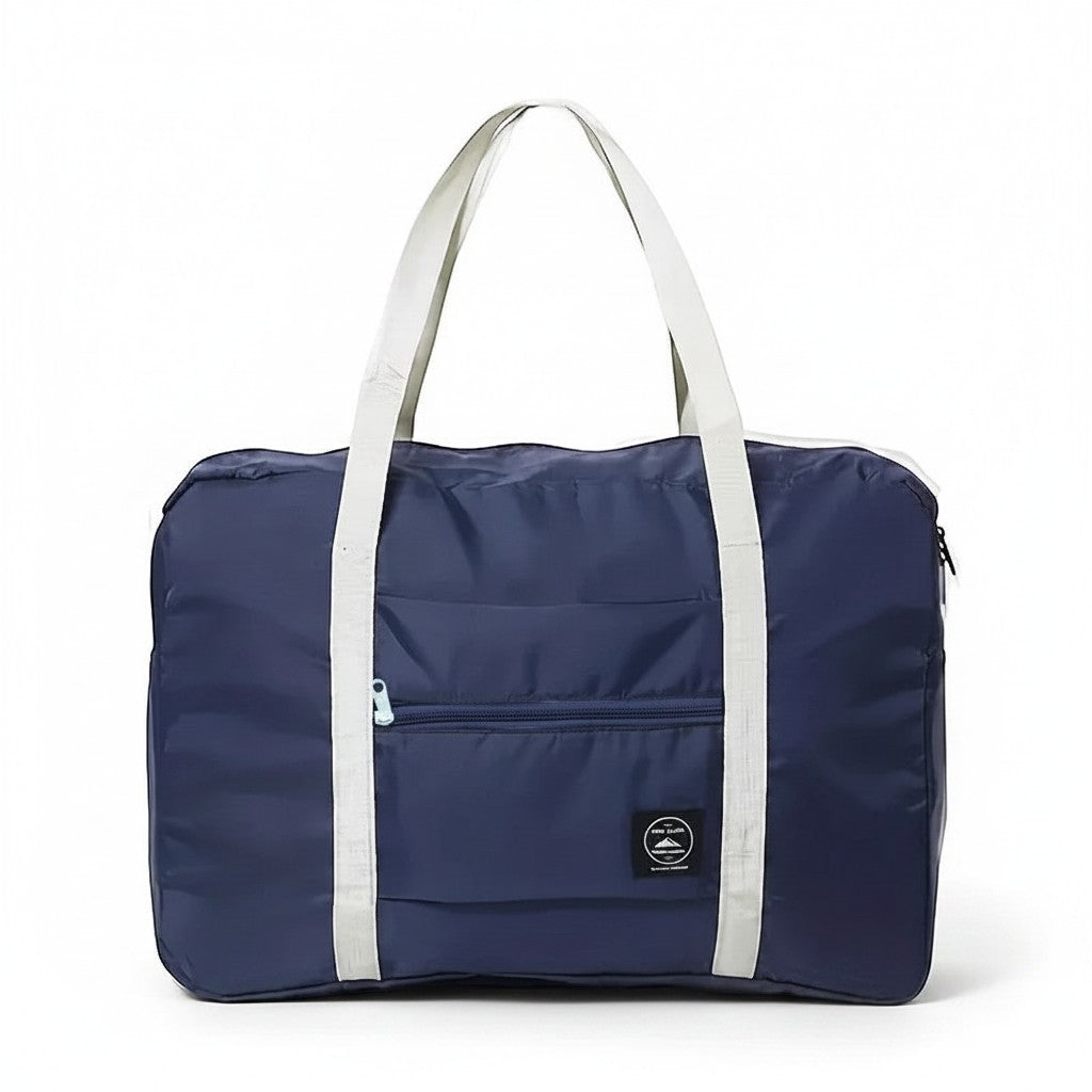 Bolsa de viaje plegable azul marino de nailon resistente al agua de Variedad Online con asas blancas y bolsillo frontal con cremallera.