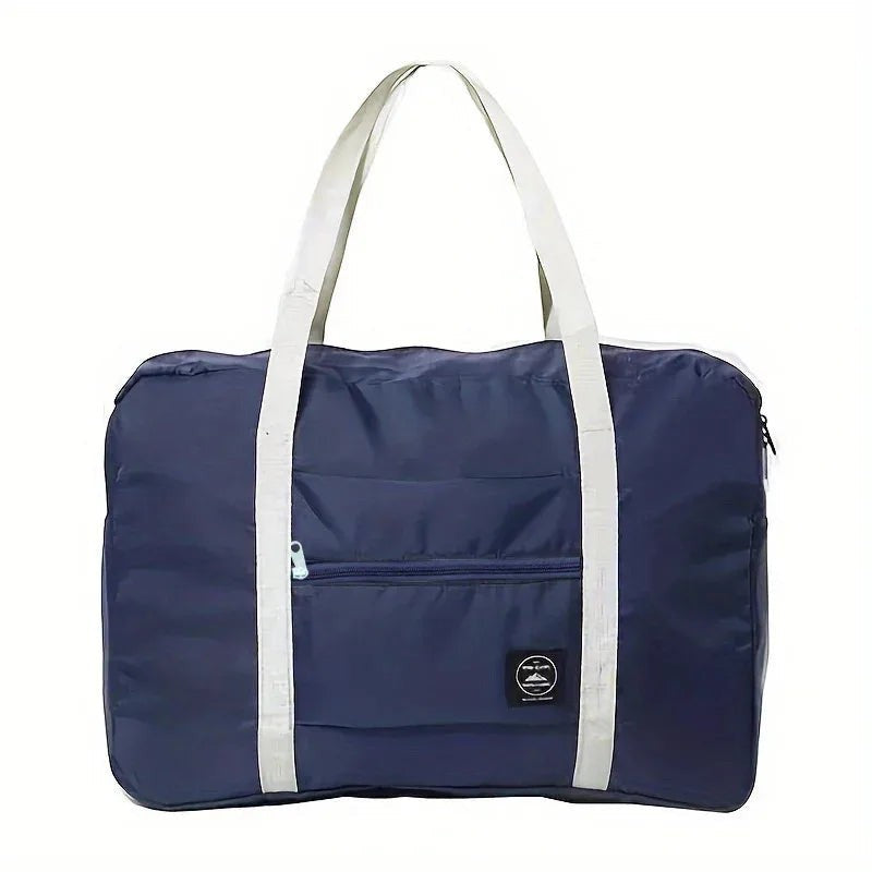 Bolsa de viaje plegable azul marino de nailon resistente al agua con asas grises y bolsillo frontal con cremallera.