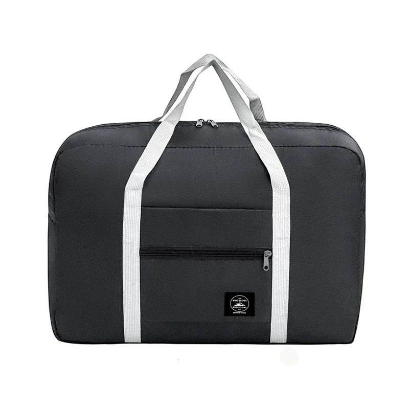 Bolsa de viaje plegable de nailon impermeable de Variedad Online en color gris oscuro con asas blancas y bolsillo frontal con cremallera.