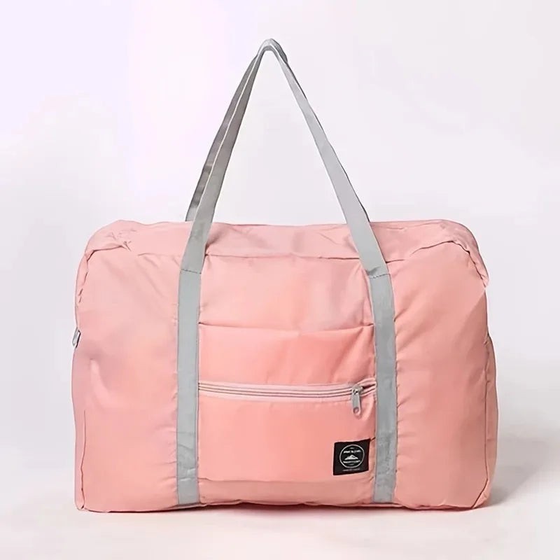 Bolsa de viaje plegable rosa de nailon resistente al agua con bolsillo frontal con cremallera y asas grises de Variedad Online.