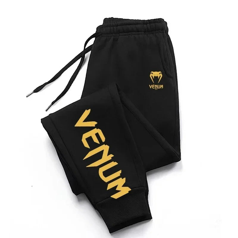 Pantalones de chándal de entrenamiento Venum negros para hombre con logo dorado y estampado lateral.